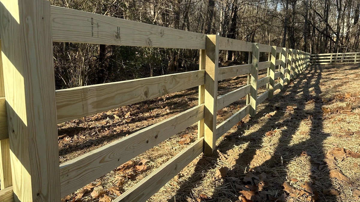 A new pressure treated privacy fence running the length of a back yard in Mooresville