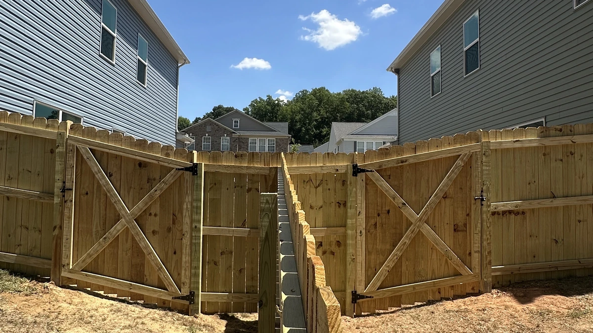 A new pressure treated privacy fence running the length of a back yard in Mooresville