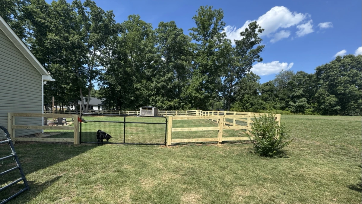 A new pressure treated privacy fence running the length of a back yard in Mooresville