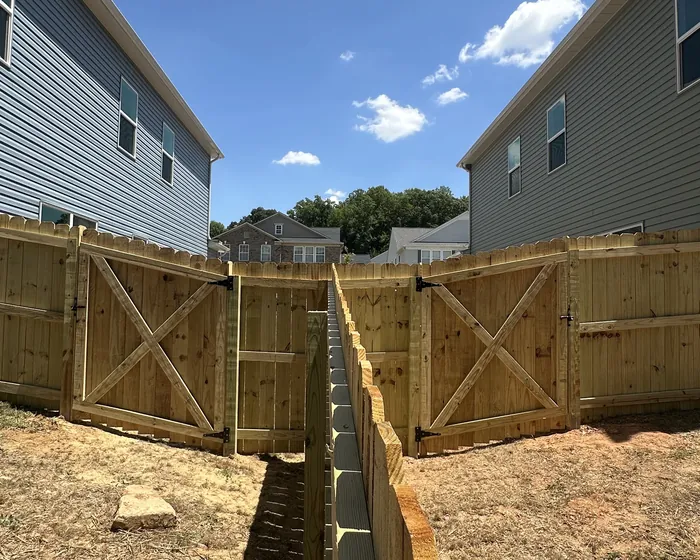 A pair of braced wooden gates hung between two houses