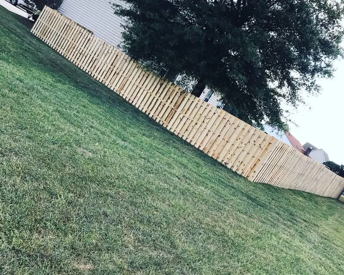 Pressure treated privacy fence following the fall of a sloping yard